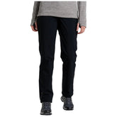 Black pants are being worn by a person who is standing upright with both hands visible near their waist in a neutral indoor setting with a plain background.