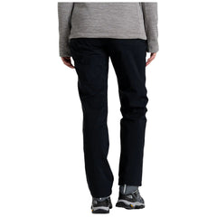 A person is wearing black pants and gray footwear standing upright wearing a gray top which suggests a casual outdoor or hiking context. They are facing away from the viewer.
