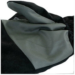 A black glove made of textured material is lying flat with a smooth gray section prominently displayed showcasing its design pattern amidst a neutral background.