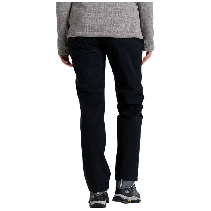 A person is wearing black pants and gray footwear standing upright wearing a gray top which suggests a casual outdoor or hiking context. They are facing away from the viewer.