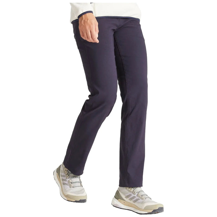 A person is walking in dark-colored pants and light-colored athletic shoes showcasing a casual outdoor attire in a neutral setting.