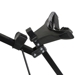 A black adjustable seat support with a padded shoulder strap is positioned at an angle on a metal frame designed for secure seating in a fitness or recreational context.