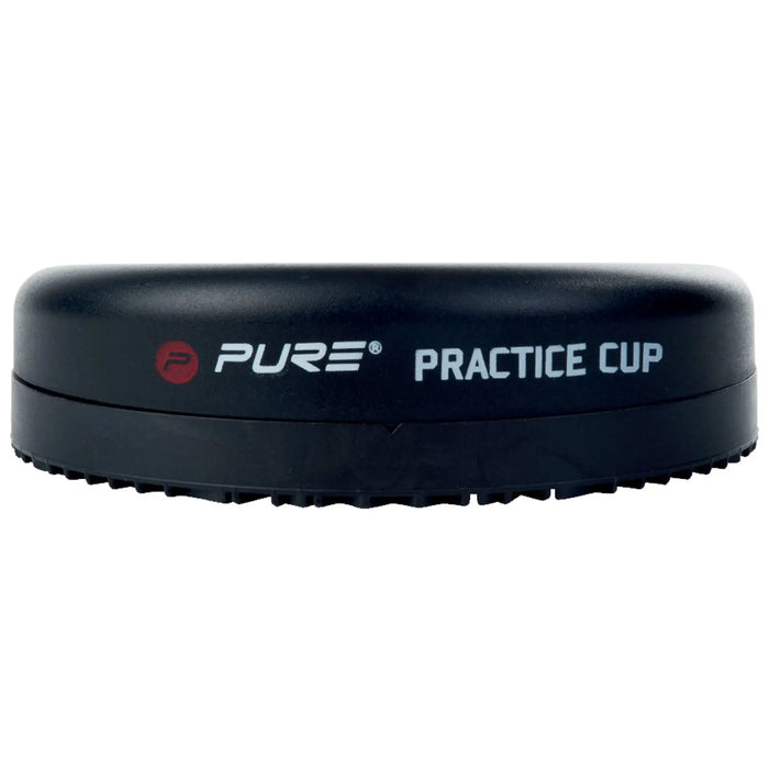 A black practice cup is resting on a flat surface with the word PURE and the phrase PRACTICE CUP displayed clearly on its side. The cup has a textured edge for grip.